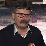 Pinguins-Manager Alfred Prey steht in der Eishalle beim Interview, während die Mannschaft hinter ihm auf dem Eis trainiert.