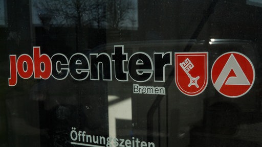 Der Schriftzug "Jobcenter Bremen" auf einer Glasfläche, daneben der Bremer Schlüssel und das Logo der Bundesagentur für Arbeit.