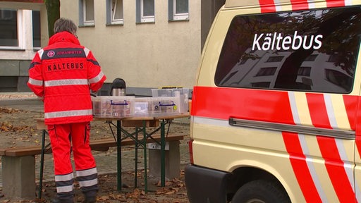 Kältebus, eine Frau stellt Sachen auf einen Tisch