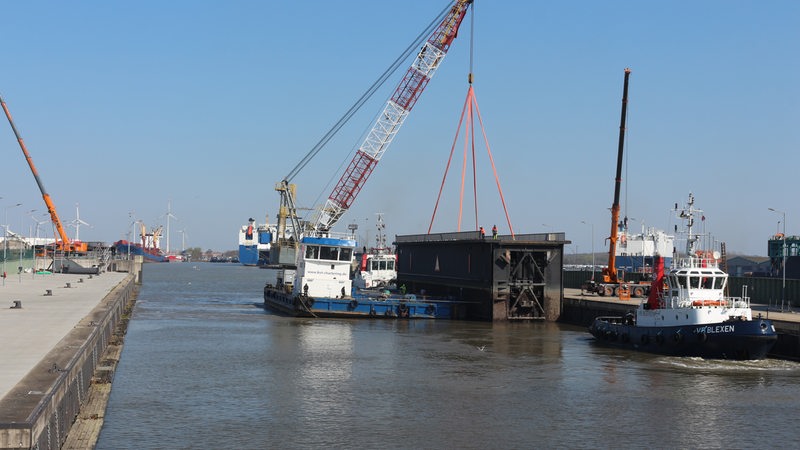 Ein Schiff hebt mit einem Kran einen Teil der Kaiserschleuse an