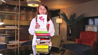 Junge mit Bücherstapel.