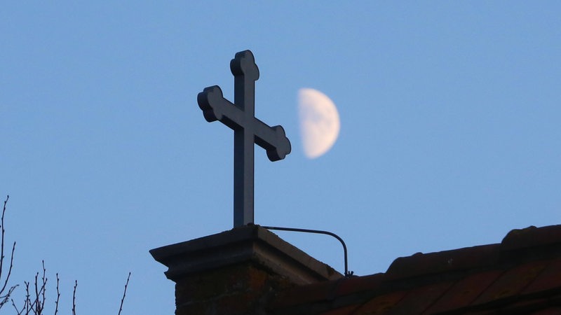 Ein Kreuz auf dem Dach einer Kirche.