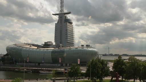 Das Klimahaus in Bremerhaven bei dunklem, bewölktem Himmel.