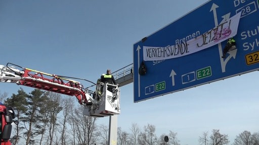 Zu sehen ist ein Polizeikran vor einem Autobahnschild.