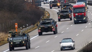 Ein Konvoi der Bundeswehr fährt auf einer Autobahn.