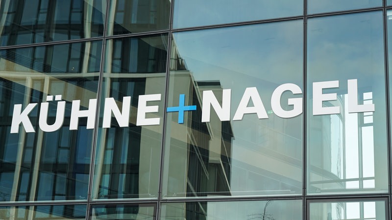 Das Logo der Firma Kühne und Nagel steht auf eine Glasfassade.