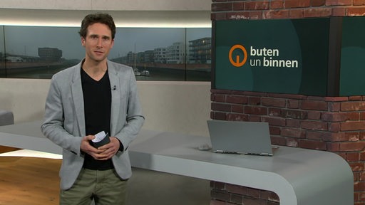 Moderator János Kereszti im Studio von buten un binnen. 