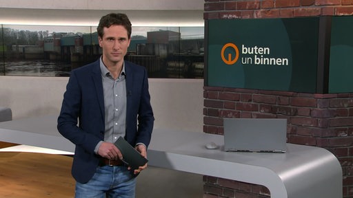 Moderator János Kereszti im Studio von buten un binnen. 