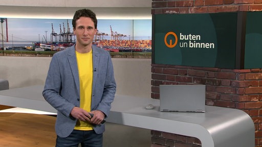 Moderator János Kereszti im Studio von buten un binnen. 