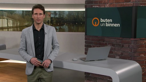 Moderator János Kereszti im Studio von buten un binnen.