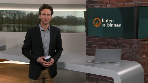 Moderator János Kereszti im Studio von buten un binnen.