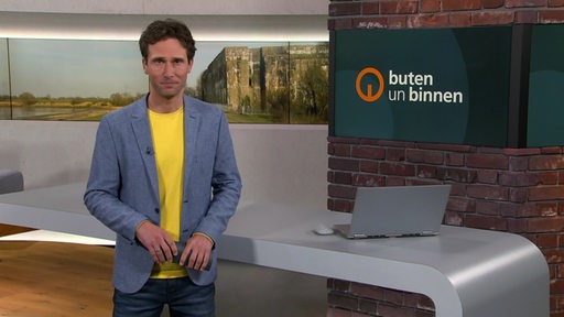 Moderator János Kereszti im Studio von buten un binnen. 