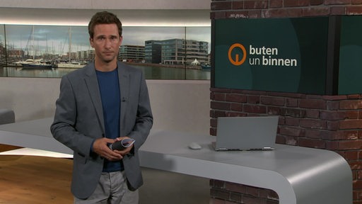 Moderator János Kereszti im Studio von buten un binnen. 