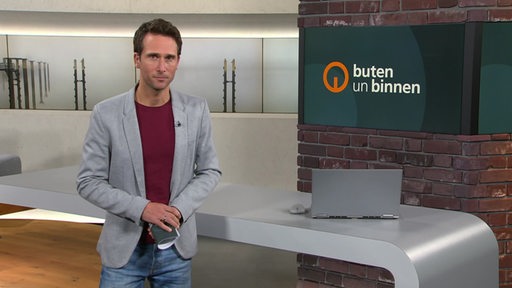 Moderator János Kereszti im Studio von buten un binnen.