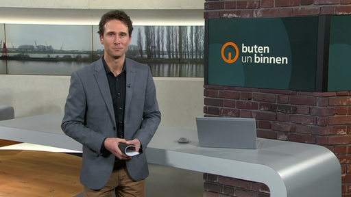 Moderator János Kereszti im Studio von buten un binnen. 