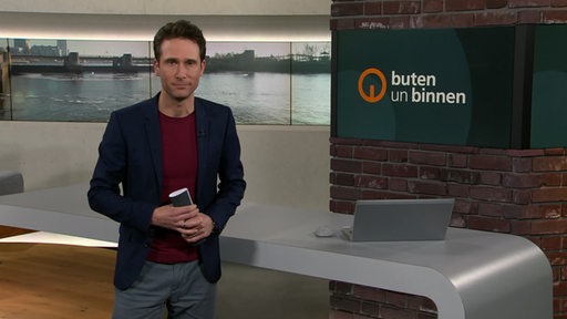 Moderator János Kereszti im Studio von buten un binnen.