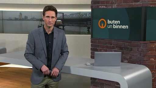 Moderator János Kereszti im Studio von buten un binnen. 