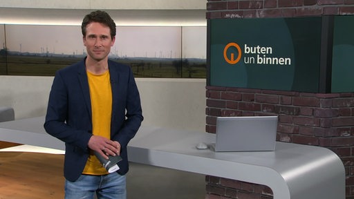 Moderator János Kereszti im Studio von buten un binnen.