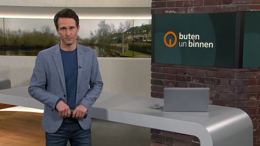 Moderator János Kereszti im Studio von buten un binnen.