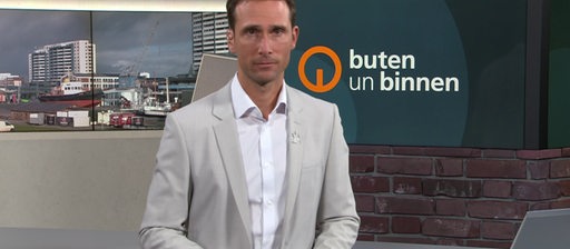 Moderator János Kereszti im Studio von buten un binnen.