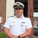 Ein Mann in blau-weißer Marineuniform an der Marineschule