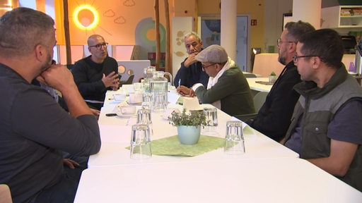 Einige Mitgleider der Marokkanischen Community sitzen an einer langen Tafel zusammen