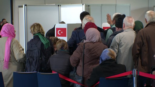 Menschen stehen dicht in einer Schlange um zu wählen