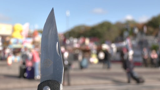 Ein großes Klappmesser. Im Hintergrund der Bremer Freimarkt. 