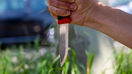 Nahaufnahme von einem Messer in der Hand eines Mannes