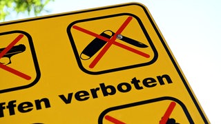 Auf einem Schild ist das Symbol für ein Messerverbot zu sehen
