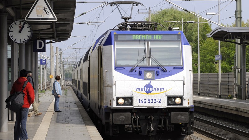 Ein Metronom mit dem Fahrtziel Bremen Hauptbahnhof hält an einem Bahnsteig am Bahnhof. 