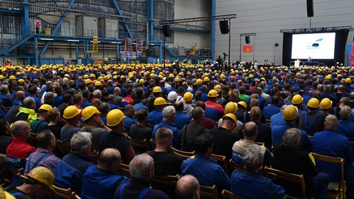 Eine Halle der Meyer Werft voll mit Menschen