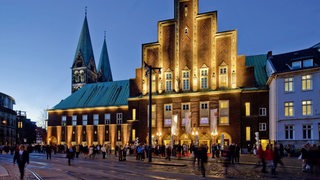 Bremens Konzerthaus "Glocke" abends von außen und mit Publikum davor fotografiert