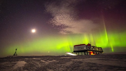 Über der Neymayer Antarktisstation leuchten der Mond und grüne Polarlichter