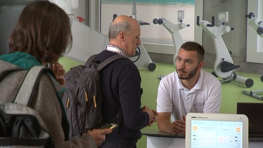 Menschen an einem Stand bei der Neuro-Tagung