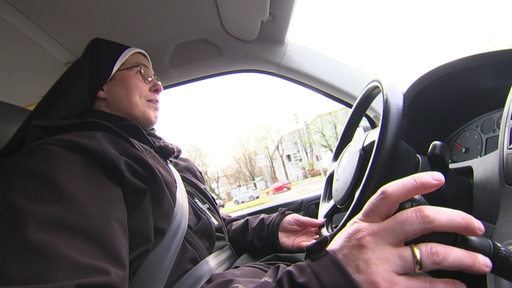 Die Nonne Schwester Deodata in ihrem Auto auf dem Weg zur Arbeit.