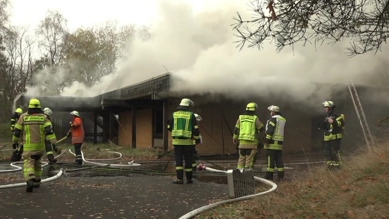 Ein Flachdachhaus qualmt, nachdem die Feuerwehr gelöscht hat.