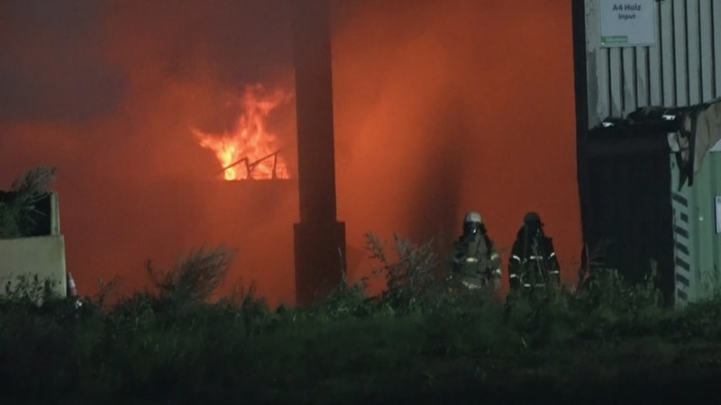 Eine Lagerhalle steht in Flammen.