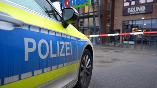 Ein Polizeiwagen steht vor einem Combi-Markt