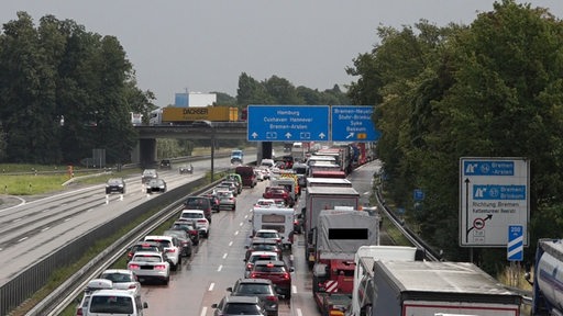 Auf einer Autobahn stehen Autos und Lkws im Stau. Sie haben eine Rettungsgasse gebildet.