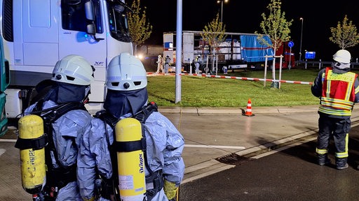 Feuerwehrleute begutachten einen Lastwagen, der Gefahrgut geladen hat.