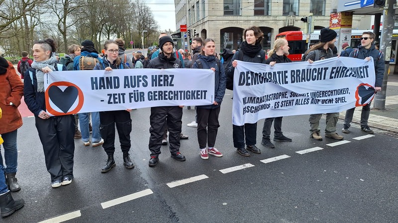 Klima-Demonstranten stehen auf einer Kreuzung