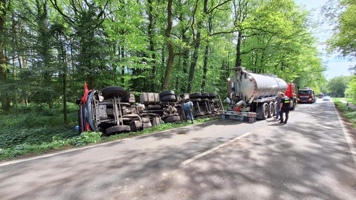 Ein Sattelschlepper liegt umgekippt im Straßengraben.