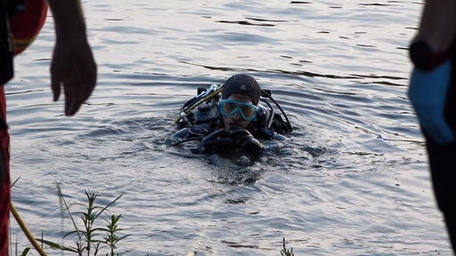 Ein Taucher taucht aus dem Wasser auf