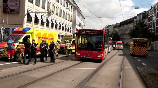 Um einen Bus stehen mehrere Einsatzkräfte der Polizei und Feuerwehr.