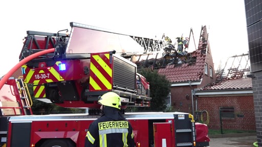 Feuerwehrleute löschen ein brennendes Wohnhaus