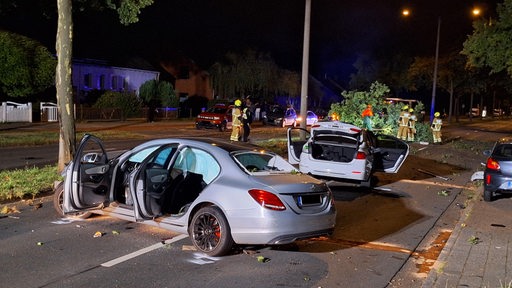 Zwei zerstörte Autos stehen auf einer Straße.