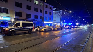 Vor einer Shisha-Bar stehen mehrere Polizeiautos.