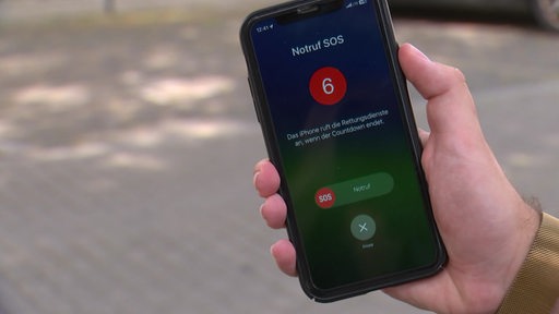 Auf einem Handybildschirm ist zu erkennen, dass der Notruf angerufen wird.