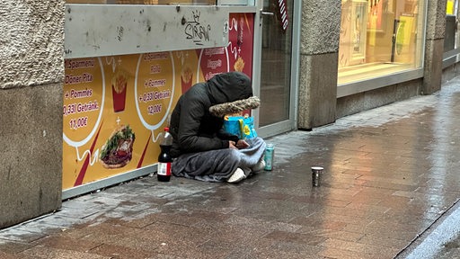 Ein Obdachloser sitz im Winter in der bremer Obernstraße in der Innenstadt.